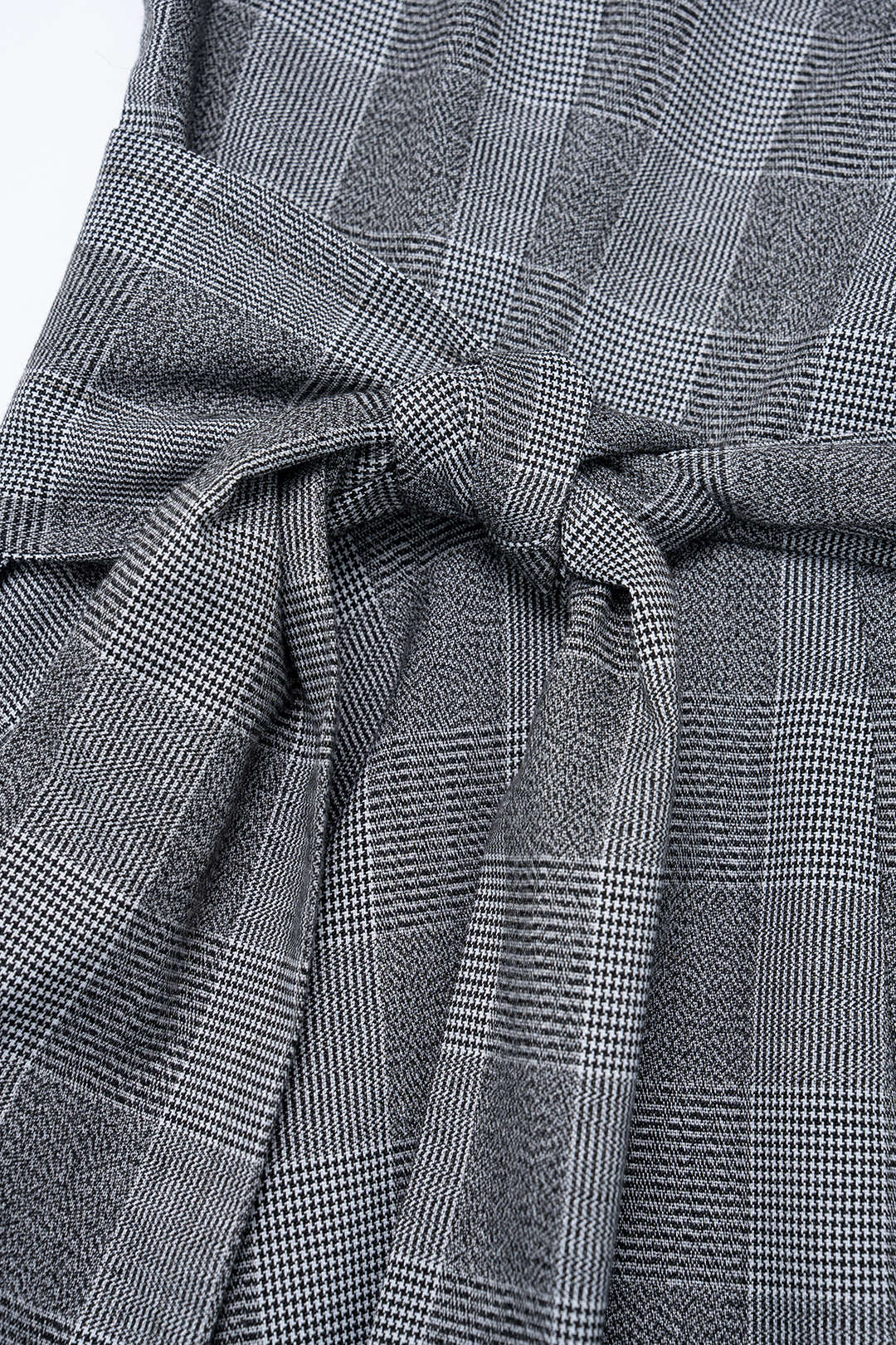 Geruite asymmetrische midijurk met V-hals en knoopdetail