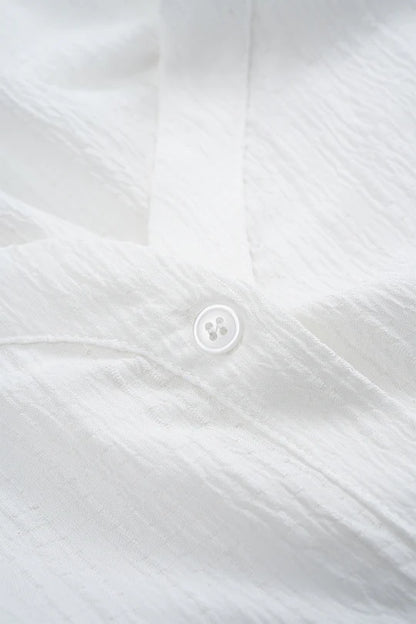 Asymmetrische, mouwloze blouse met knoopsluiting en open rug